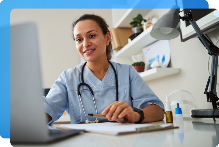 Nurse working at her computer entering patient information.
